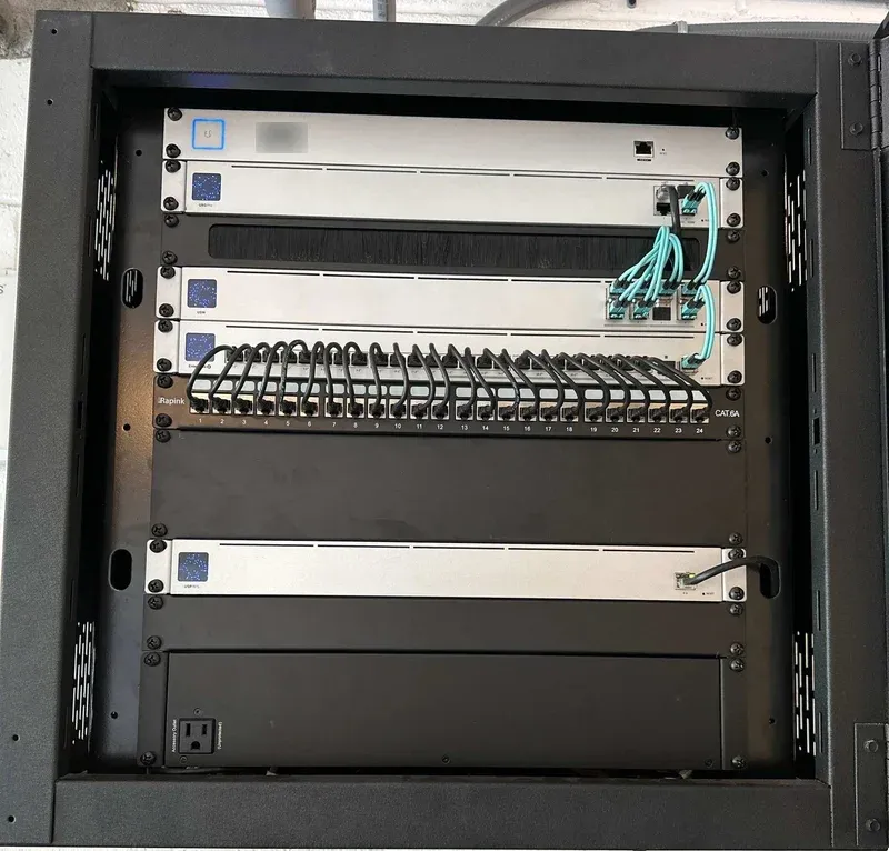 Wall-mounted network rack with switches and a wired patch panel