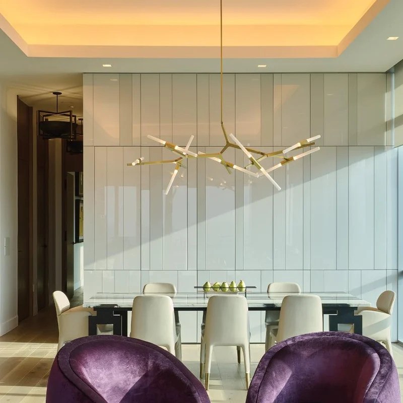 Dining area with warm ceiling cove lighting and daylight