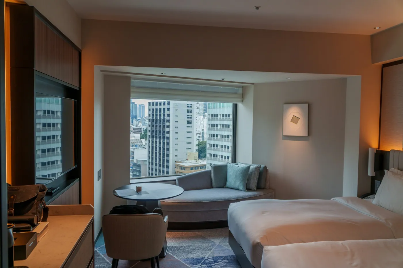 Select-service hotel guest room with two beds, sofa and wall television