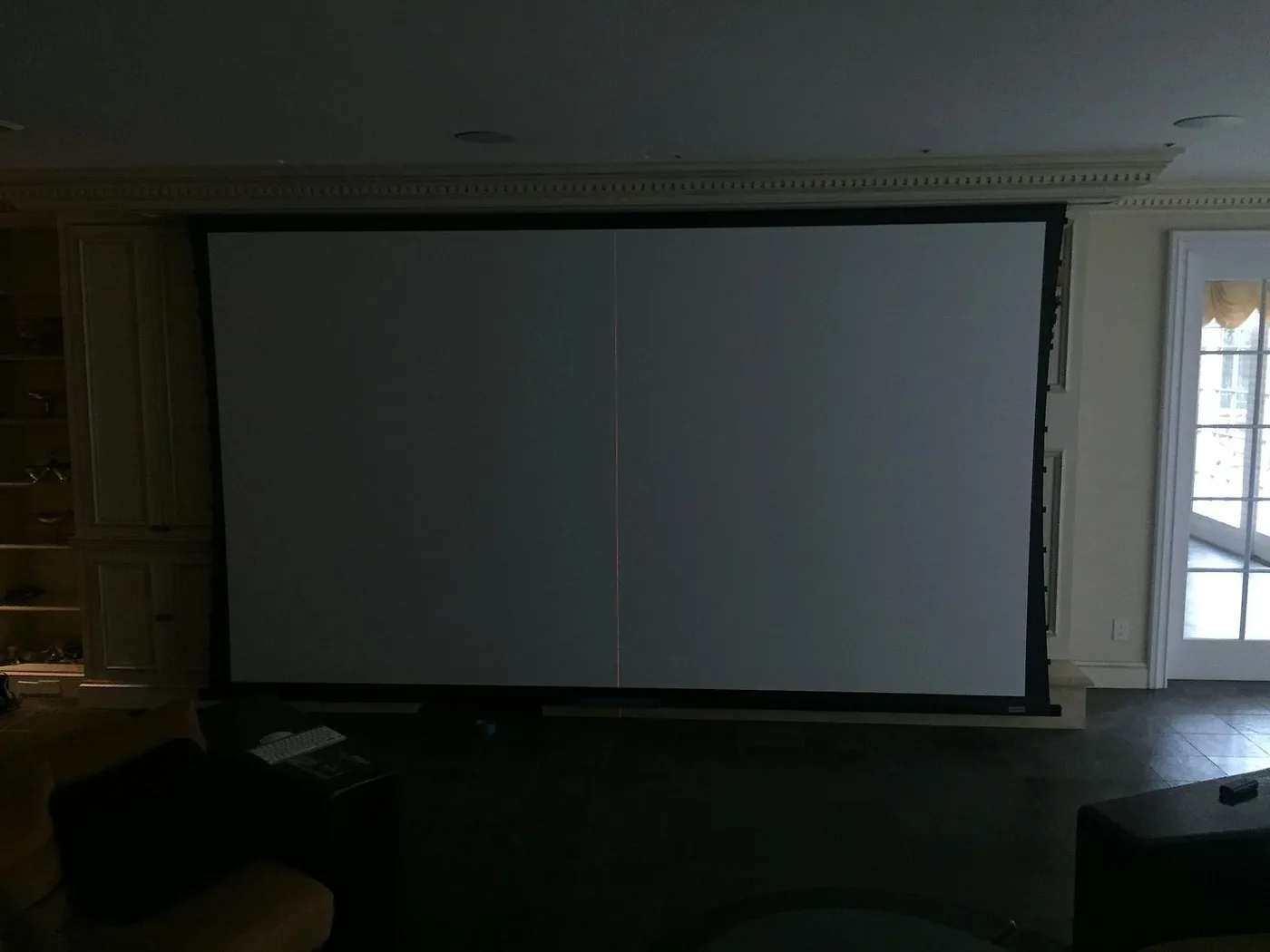 Large projection screen with nothing displayed in a darkened media room
