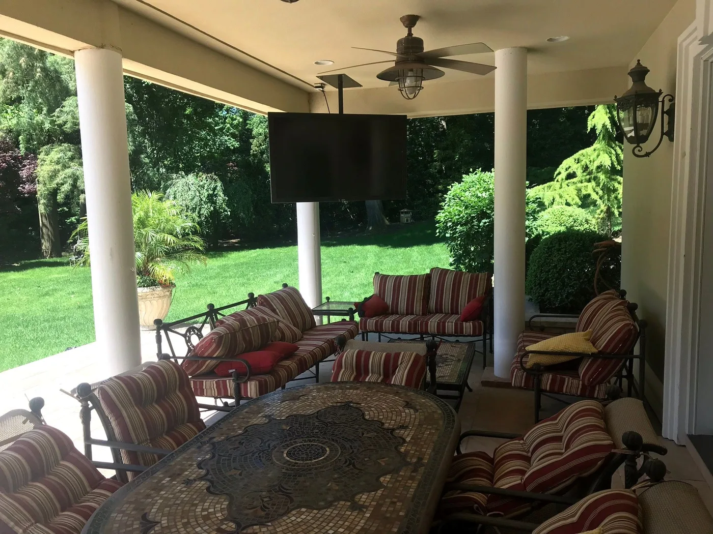 Ceiling-mounted television and speakers on a covered terrace