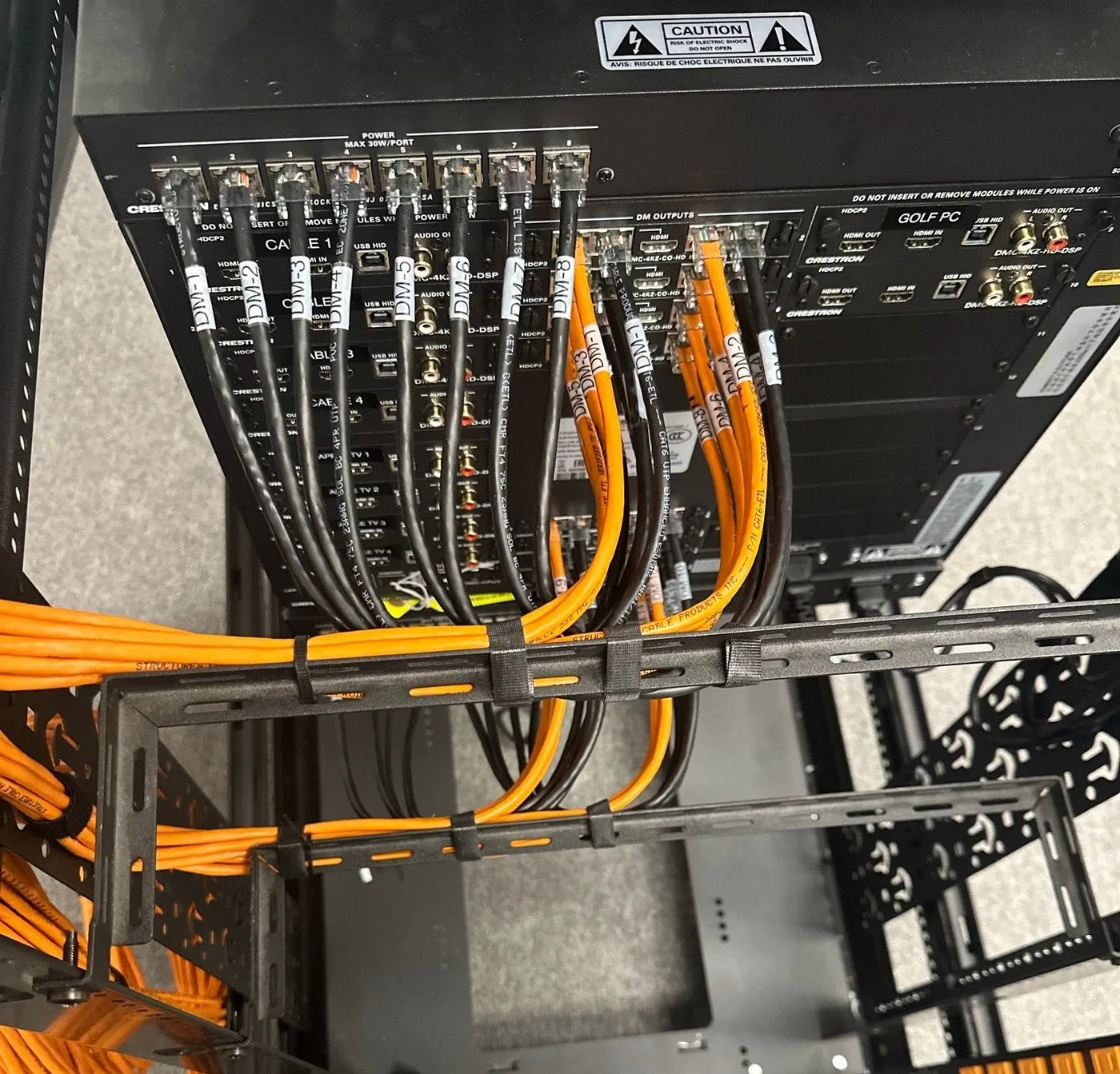 Labeled Crestron video connections supported on rack lacing bars