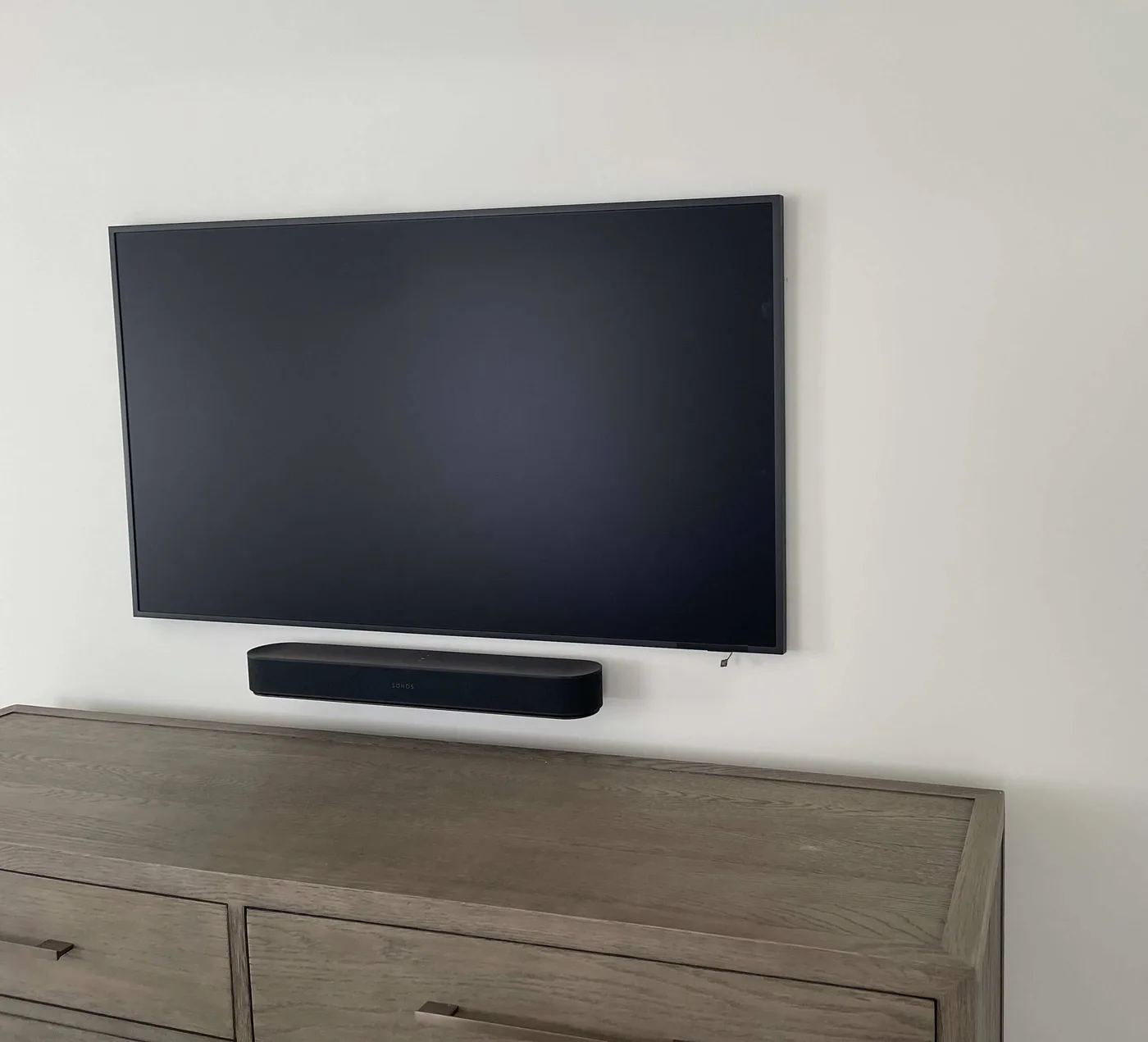 Wall-mounted display and soundbar above residential cabinetry