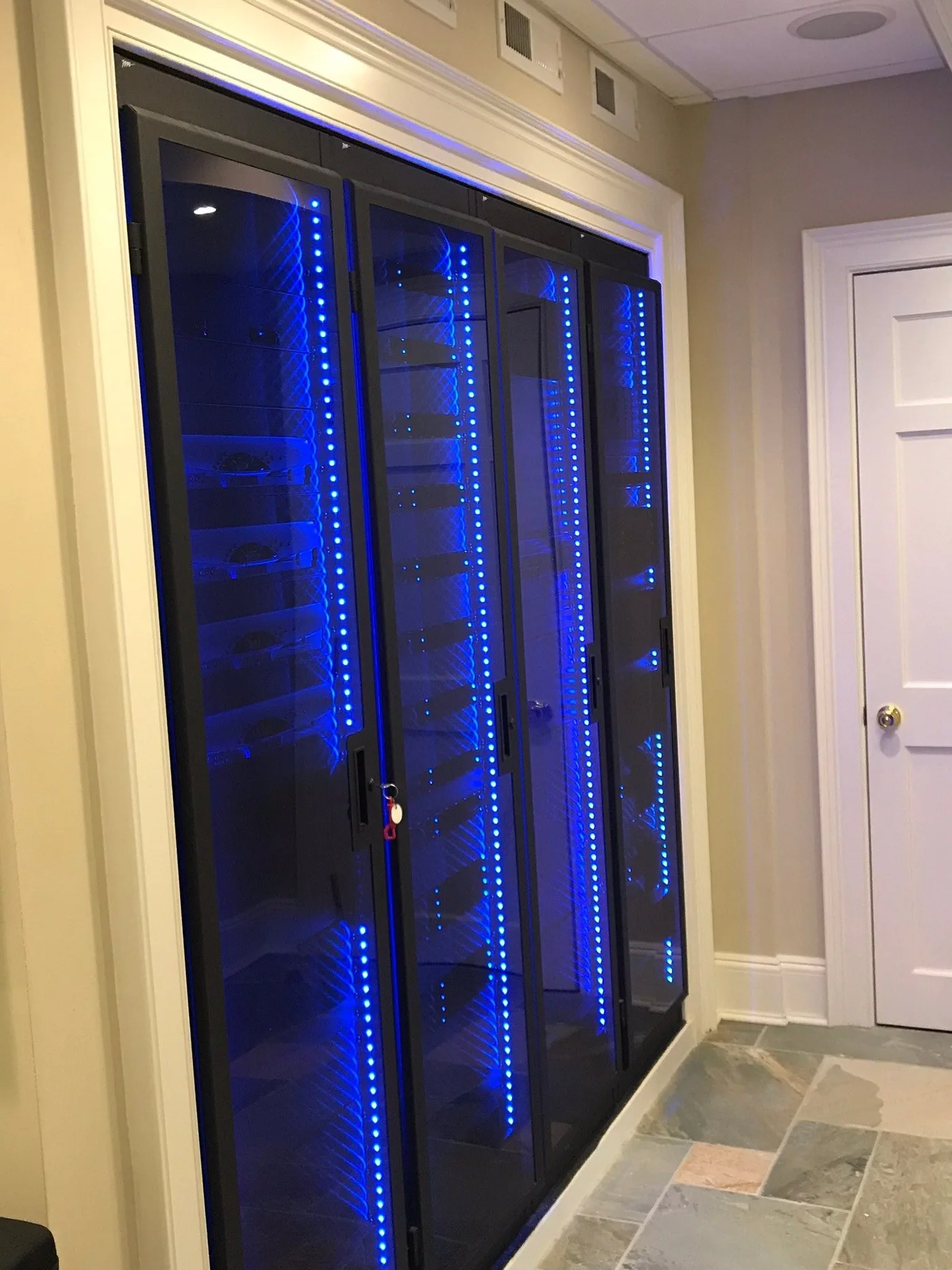 Enclosed equipment racks with internal lighting in a finished technology room