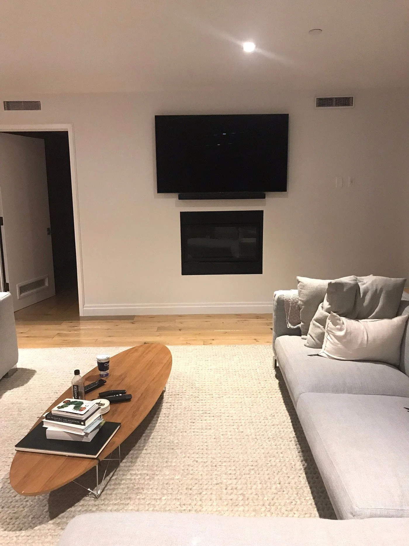 Television and soundbar above a fireplace in a finished living room