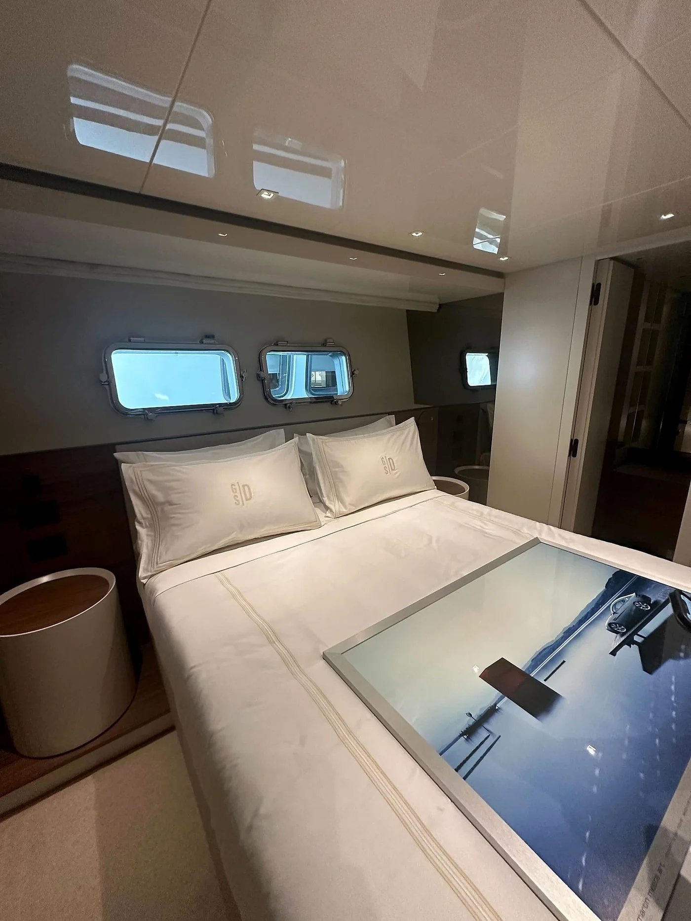 Yacht stateroom with upholstered headboard and hull windows